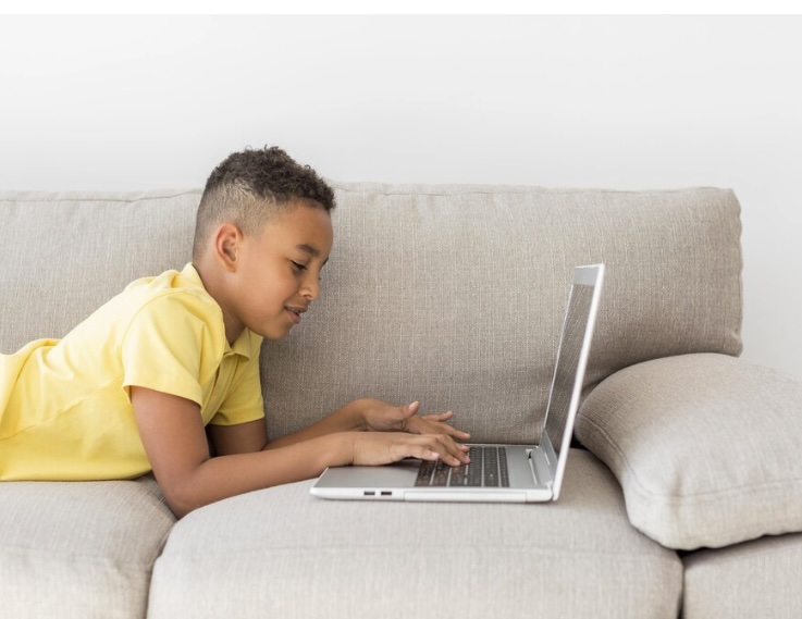 Child typing on a laptop