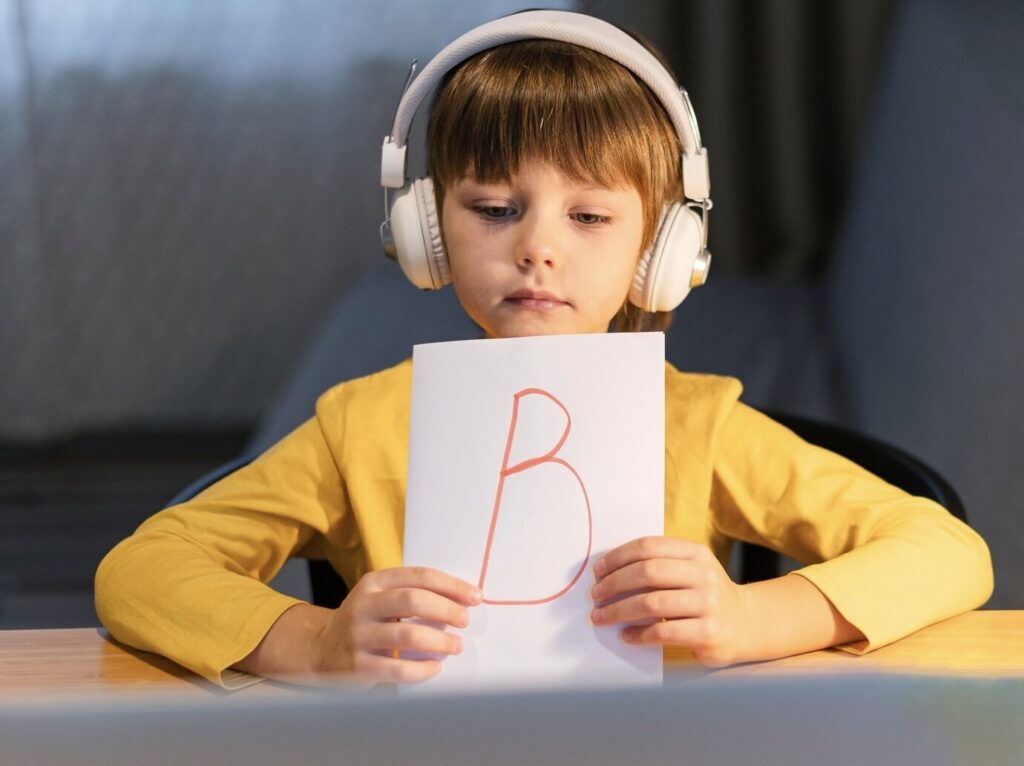 Boy showing a paper with the letter b