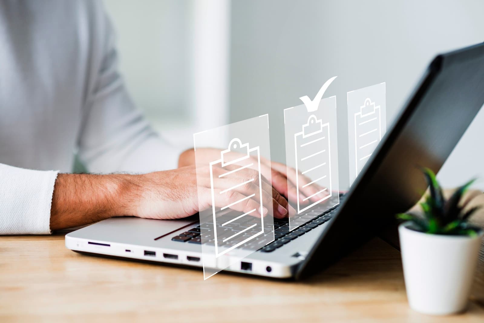 Man's hands on laptop keyboard with virtual documents